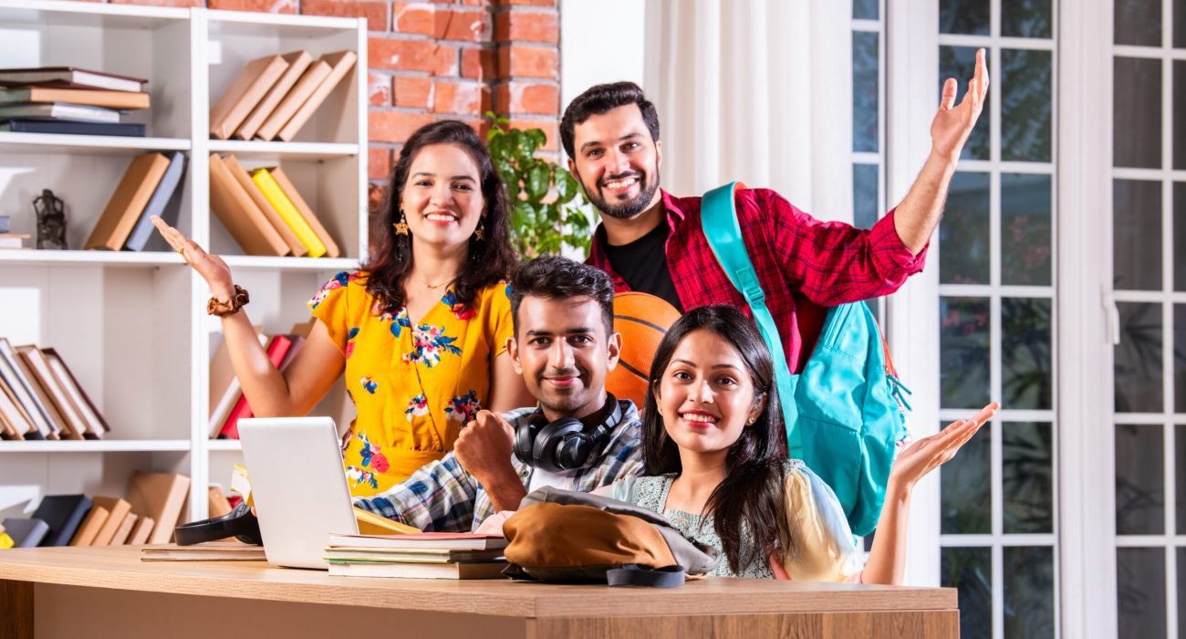 Indian asian four college or university students using laptop for study at table